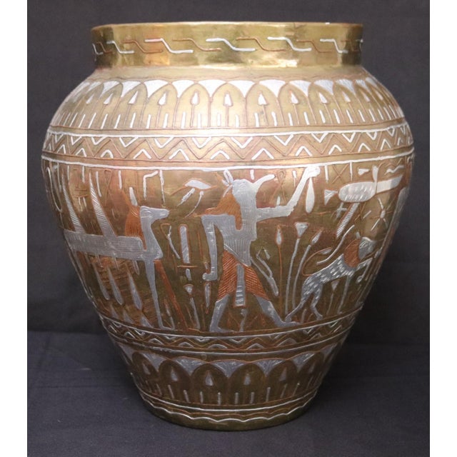 A striking vintage Egyptian Cairo Ware brass vase featuring intricate hand engraving with copper and white metal inlay....