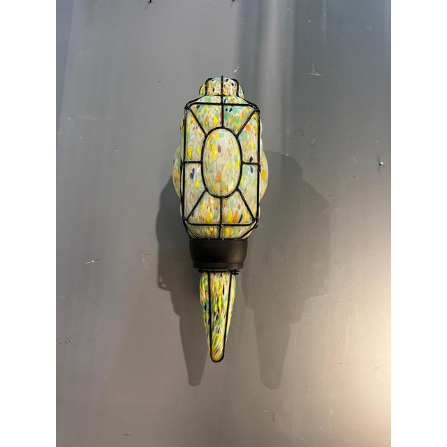 An elegant polychrome Murano glass wall light, crafted in Italy in the second half of the 20th century. The light fixture...