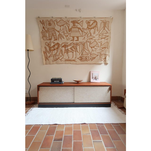A very low teak sideboard from the 1960s, 164 cm long and only 52 cm high. Two wide sliding doors are framed in wood and...