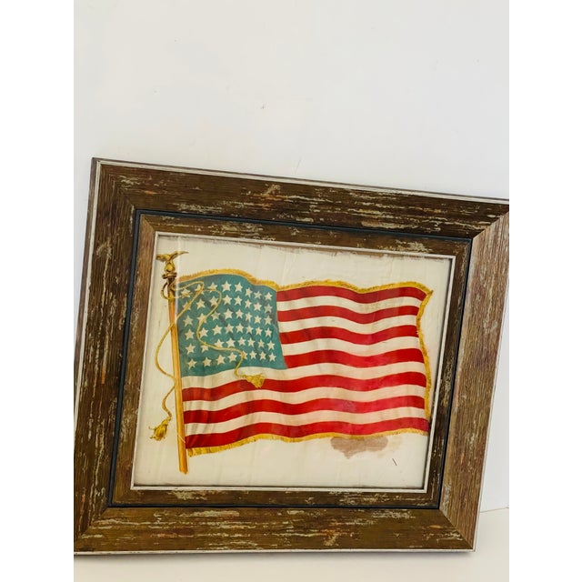Antique 48 Stars American Flag on cotton silk , distressed and framed in a rustic frame.