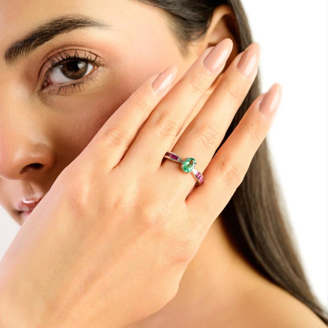 This dainty promise ring is crafted in 925 solid silver and features a beautiful combination of oval emerald and square...