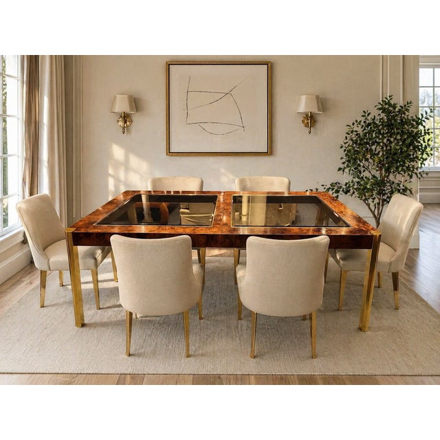 A striking 1970s dining table by Century Furniture, featuring richly figured burl wood paired with sleek brass legs for a...