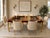 A striking 1970s dining table by Century Furniture, featuring richly figured burl wood paired with sleek brass legs for a...