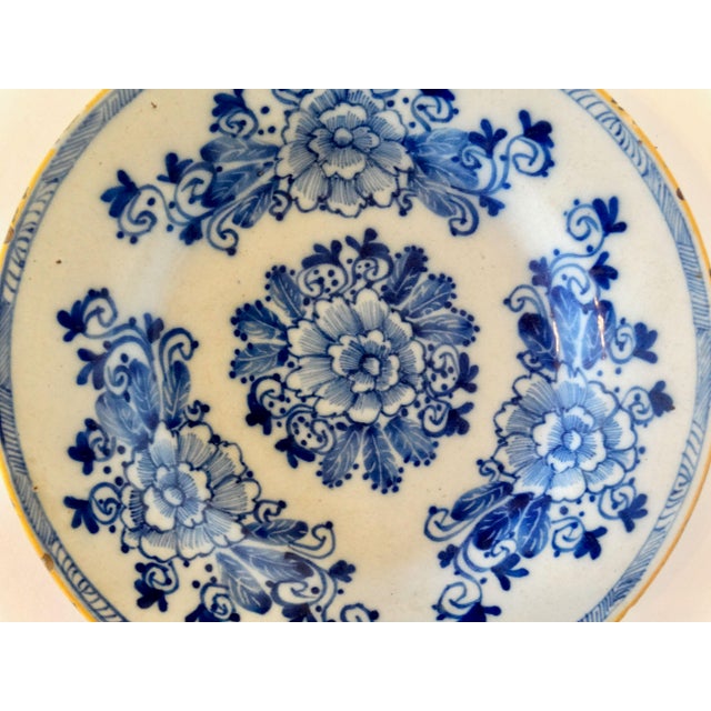 A superb 18th-Century Dutch Delftware plate by the factory Porceleyne Bijl. It is hand painted with a floral design with a...