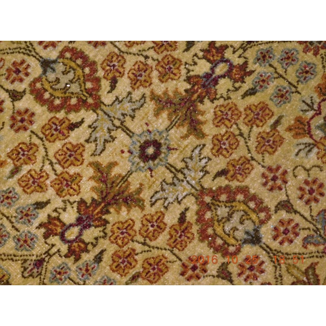 Intricate floral pattern in golden tone. Wool pile on cotton foundation. Extra wide main border displaying stylized...