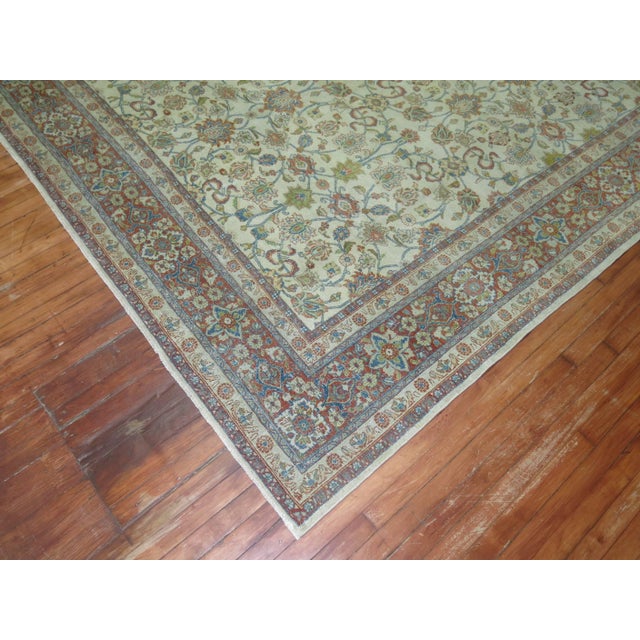 An early 20th century Persian Kashan rug consisting of an ivory field with soft accents in blue, green and red. 8'5'' x...