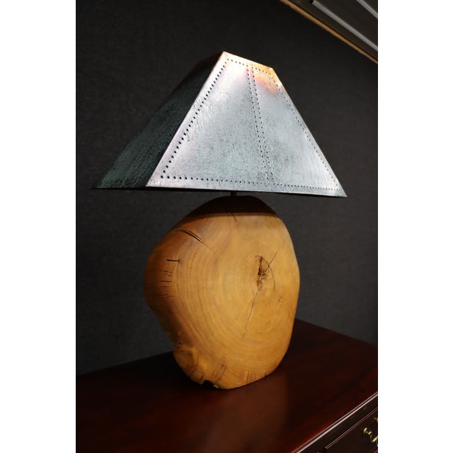 Mid-century modern table lamp featuring a solid live edge wood base with a sculptural, organic form and visible grain....