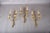 Set of three brass wall sconces with a rope-and-tassel motif. Each has two curved arms springing from a central knot,...