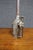 Antique metal oil can featuring a cylindrical body, fitted handle, domed shoulder, and exceptionally long, narrow curved...