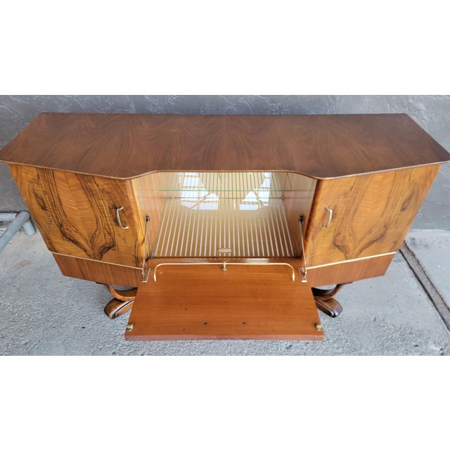 A burl walnut drop-front dry bar by Beautility. England, circa. 1950's. Beautiful book-matched walnut veneer. Glass...