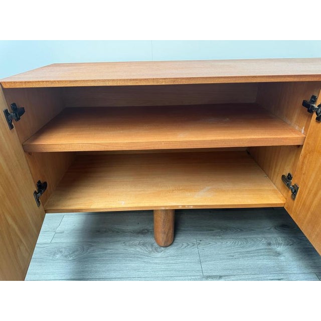A fabulous Italian C1960s four doors credenza in oak wood resting on four cylindrical wooden legs to the base . The front...