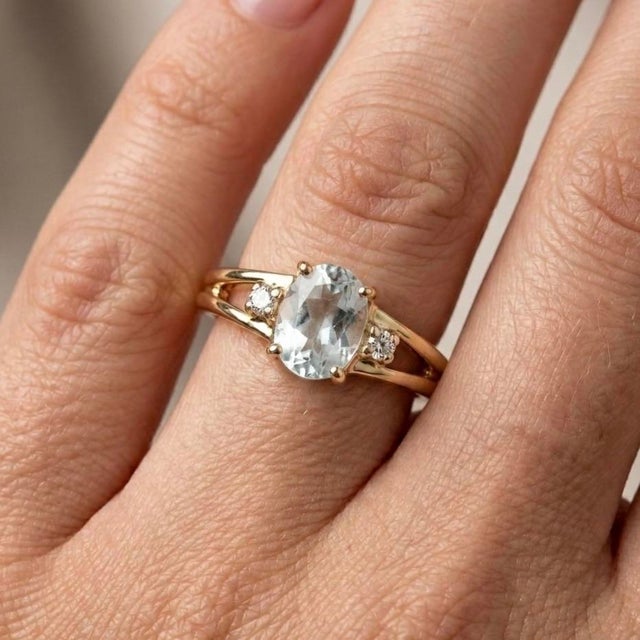 Indulge in the serene elegance of this meticulously crafted three-stone cocktail ring, a breathtaking blend of...