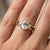 Indulge in the serene elegance of this meticulously crafted three-stone cocktail ring, a breathtaking blend of...
