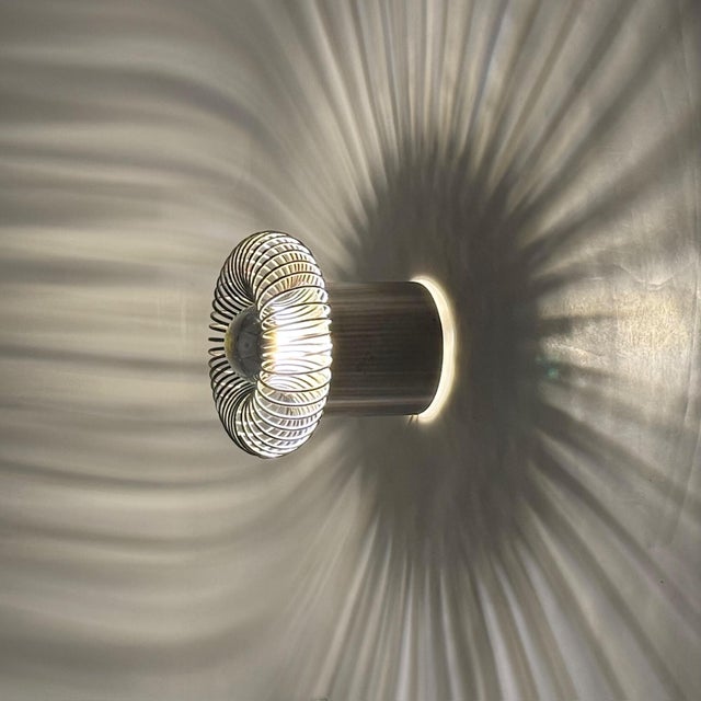 Wall mounted lamp attributed to philippe rogier and produced by oxar in france during the 1970s. the fixture consists of a...