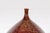 A bulb shaped ceramic handcrafted vase with burgundy brown textured finish, honeycomb style motifs and narrow mouth....