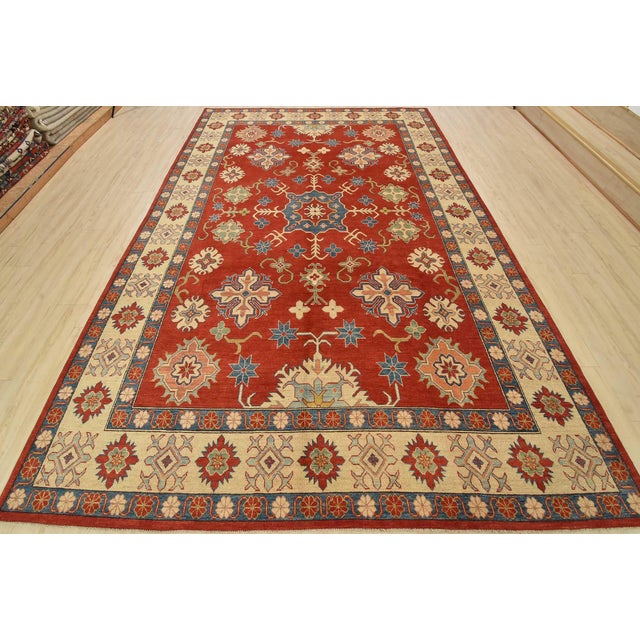A tribal Caucasian Kazak rug hand-knotted with fine wool on a cotton foundation. This rug features a central medallion...