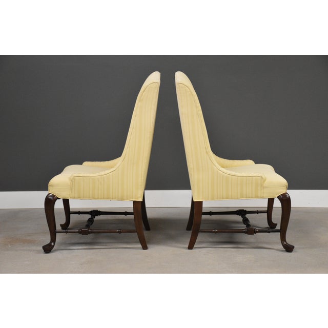 A pair of traditional Queen Anne style lounge chairs or captains chairs made by Ethan Allen Furniture. Cherry cabriole...