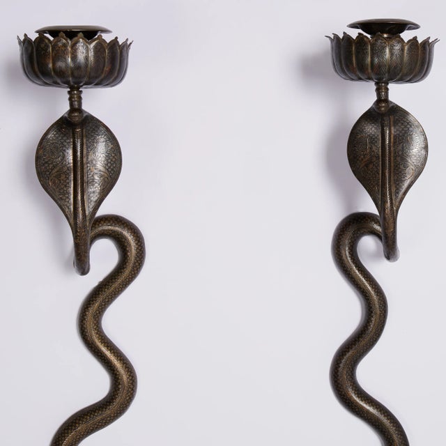 Standout pair of vintage Anglo Indian cobra or snake wall sconces crafted in brass with etched floral and geometric...