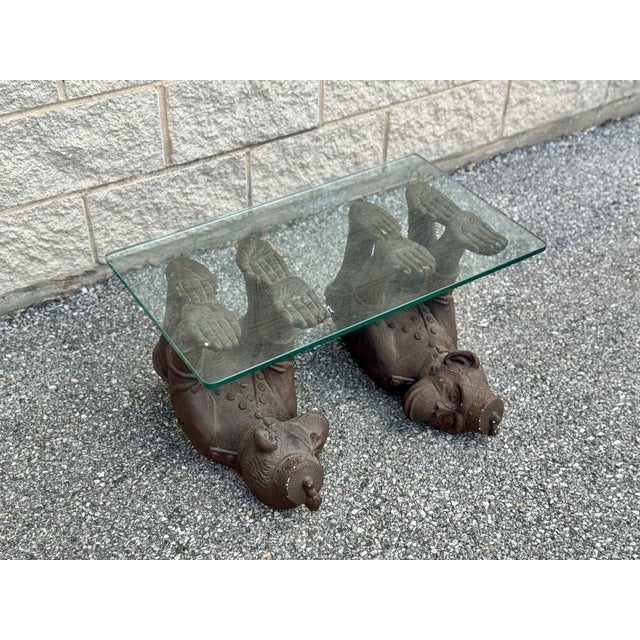 Coffee table with a rectangular glass top supported by two figural monkey bases. Each figure is modeled in a reclining...