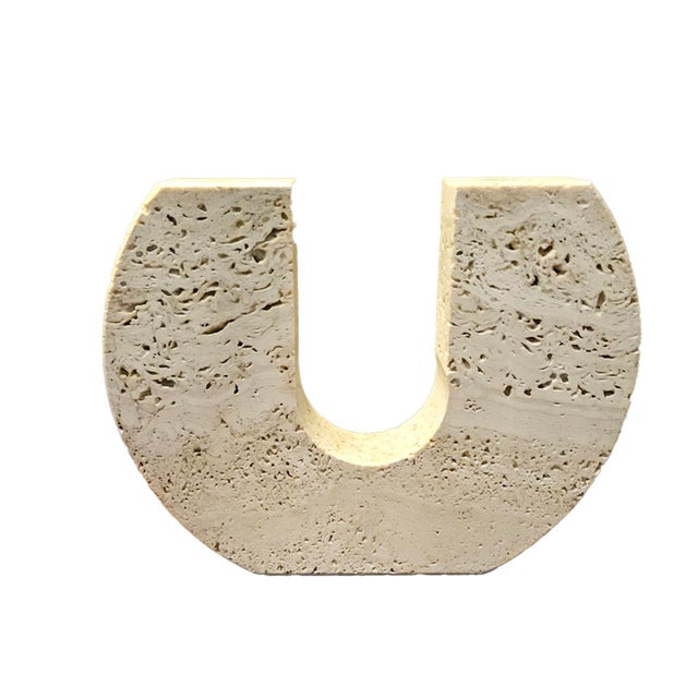 Travertine at its most sculptural: a solid block of Italian stone carved into a bold horseshoe U, with a socket in each...