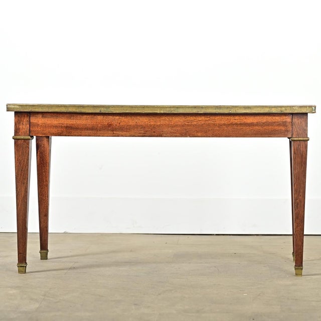 Dimensions: 19 ⅞” H x 35 ⅝” W x 18” D French vintage (early 20th century) mahogany coffee-cocktail table in the Louis XVI...