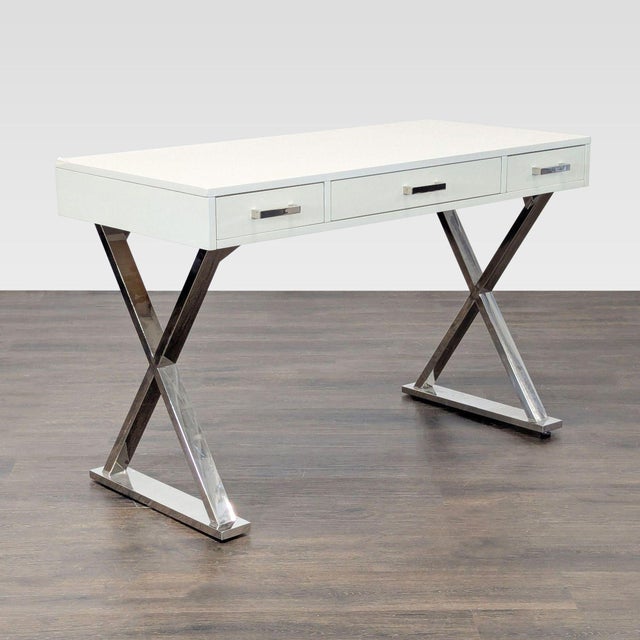 This modern desk features a clean white finish with sleek chrome legs, giving it a contemporary look. It has three...