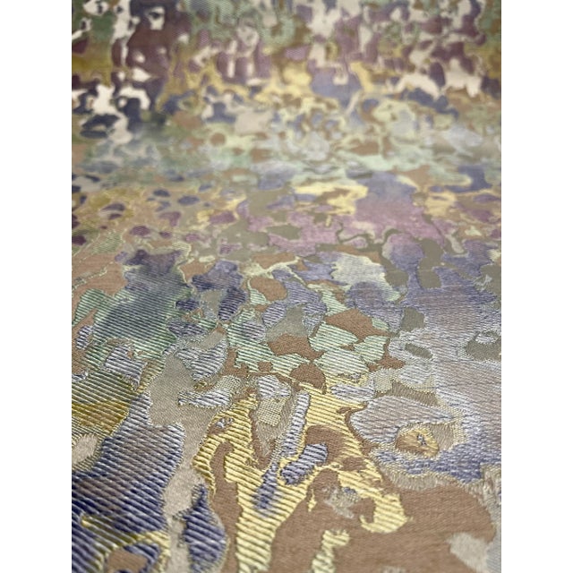 This fabric is a modern camouflage with a mix of colors like green, blue, purple, silver. It has a medium hand and is it...