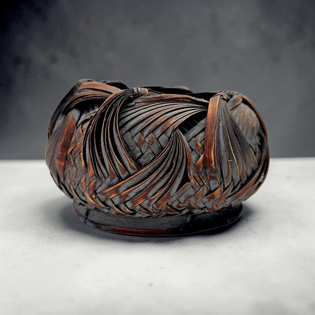 Japanese bamboo ikebana basket dating to the Showa period, circa 1940s–1970s. Handwoven from split bamboo with a smoked...