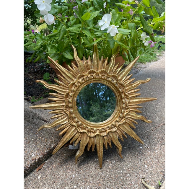 A very glamorous French Style Gilded Resin Sunburst Wall Mirror from the 1960s. This fabulous 16.5" wall mirror features...