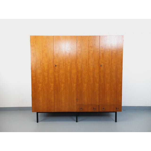 Vintage 1960s modernist style teak wardrobe with square tubular black metal legs. Ample storage: four doors with hanging...