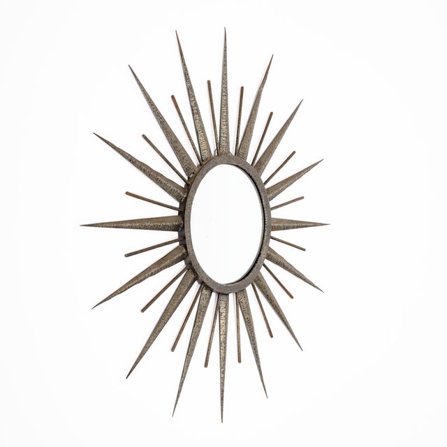 Striking French Mid-Century Modern sunburst mirror, circa 1960, handcrafted from embossed and hand-hammered metal....