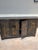 A striking vintage Chinese black lacquer sideboard showcasing beautifully hand-painted gilt decoration inspired by the...