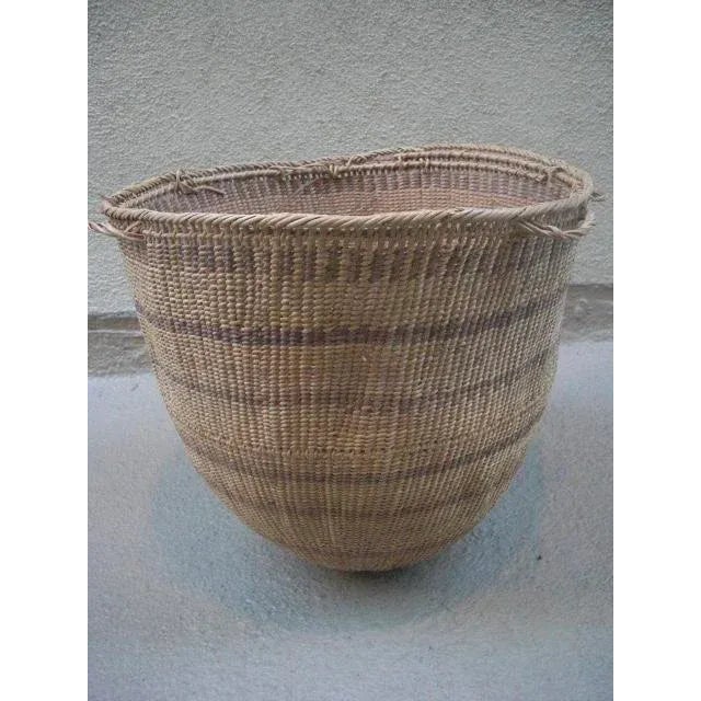 This vintage Yanomami gathering basket has variegated stripes of darker reeds woven throughout the design of this tightly...