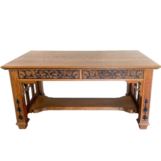 A fine Gothic Revival library table constructed in oak with carved and ebonite appliqués. The rectangular top over two...