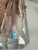 Hand cut thick crystal perfume bottle featuring an elegant floral scene etched on its surface. The intricate design and...
