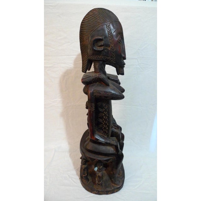 Offered is a large wood carved male and female seated primordial couple. On the backs of the figures, the male figure has...