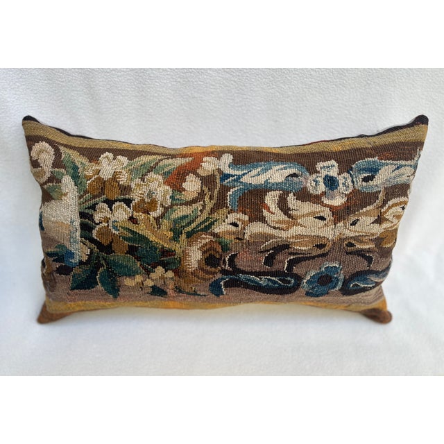 A charming decorative pillow crafted from an exquisite 18th-century tapestry featuring a striking pattern of beautifully...