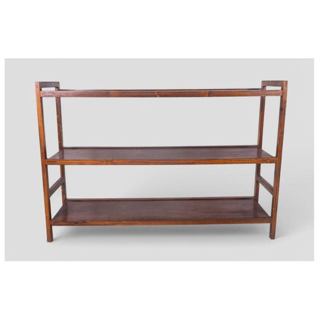 A wooden shelving unit with a timeless, understated style, dating back to the 1960s. Its simple yet well-balanced...
