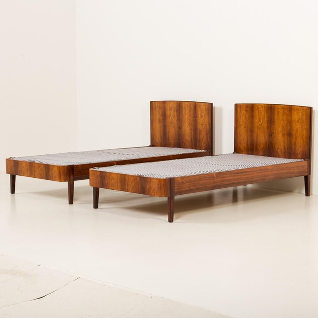 This pair of Danish single pau ferro rosewood bed frames was made some time in the 1960s. Crafted from solid rosewood and...