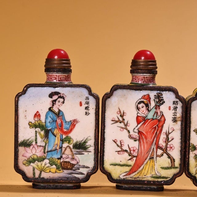 This is a set of four matching cloisonné enamel snuff bottles, each featuring a hand-painted portrait of one of the "Four...