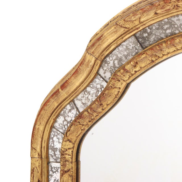 This exceptional large-scale mirror features a graceful arched form enclosed within a finely carved giltwood frame of...