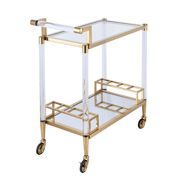 The Glacia Bar Cart features two glass trays set within a lucite body, accented with gold-plated stainless steel. Its...