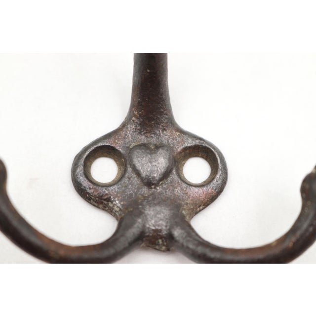 Vintage cast iron triple arm acorn wall hook with a black finish and raised heart in the center. The original mounting...