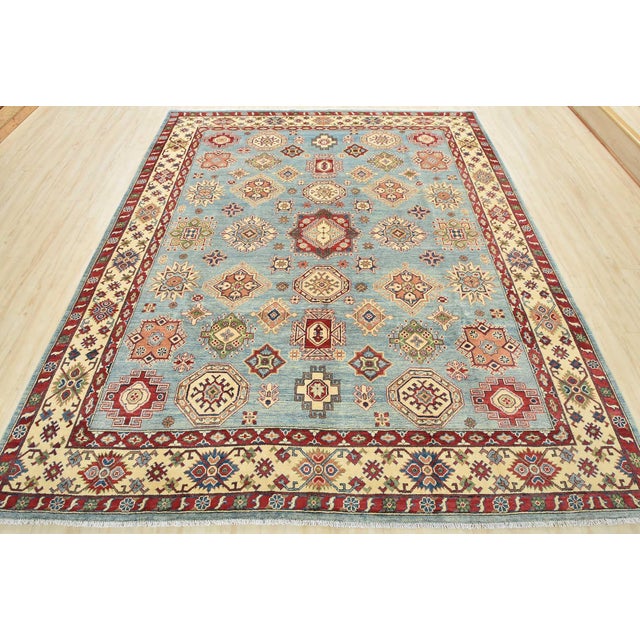 This traditional tribal geometric Caucasian Kazak rug is hand-knotted with an all-wool pile on a cotton foundation. This...