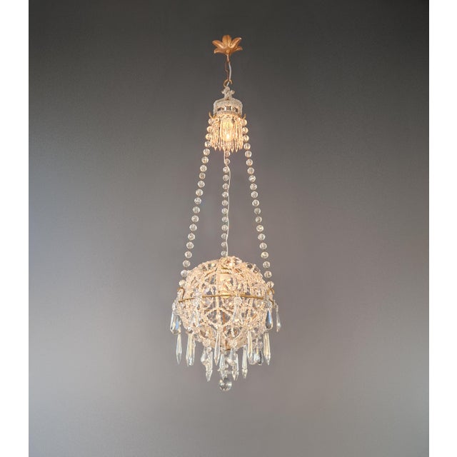 A distinctive chandelier designed as a closed crystal body with a compact sphere basket form. Fully restored in our Berlin...