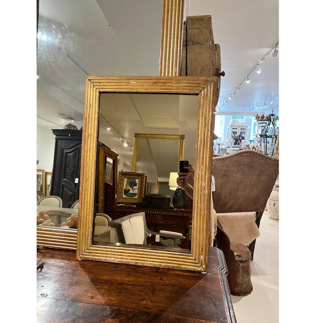 A charming 19th-century French Louis XVI mirror crafted in giltwood, showcasing classic neoclassical lines, delicate...