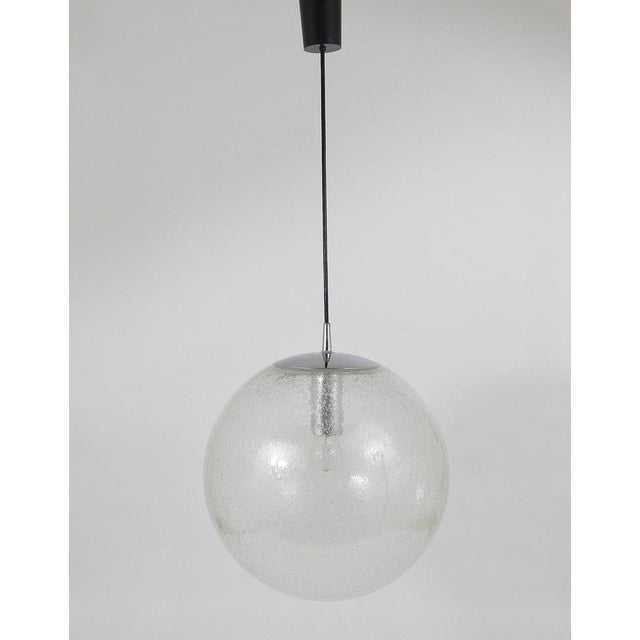 A beautiful Space Age pendant light with an extra large glass globe and chrome-plated hardware. The globe is made of hand...