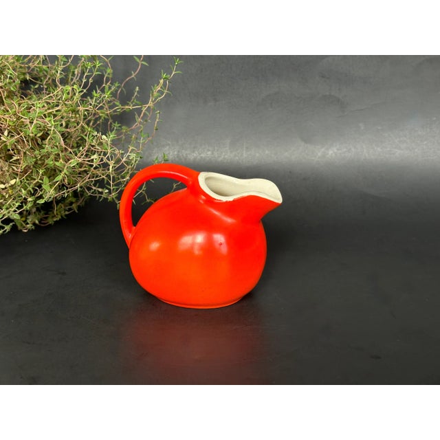 This vintage miniature 1940s pitcher will add a color pop to your retro kitchen decor. The small orange red pitcher can be...
