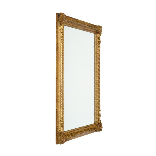 Napoleon III Mirror from France with an intricately hand-carved frame. The frame is finished with its original 24 carats...