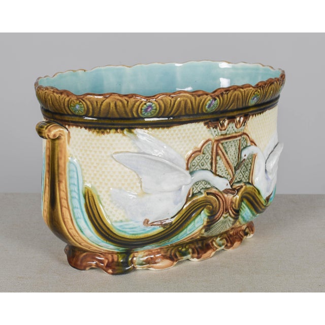 A large late 19th century French Barbotine jardiniere, or cache pot, with swan motif. Hand-painted glazed ceramic with...